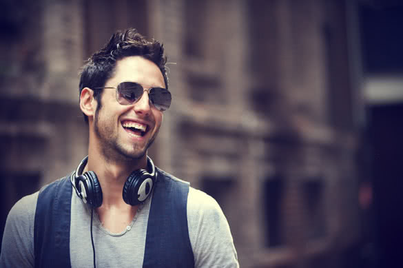 stylish man laughing with sunglasses and headphones